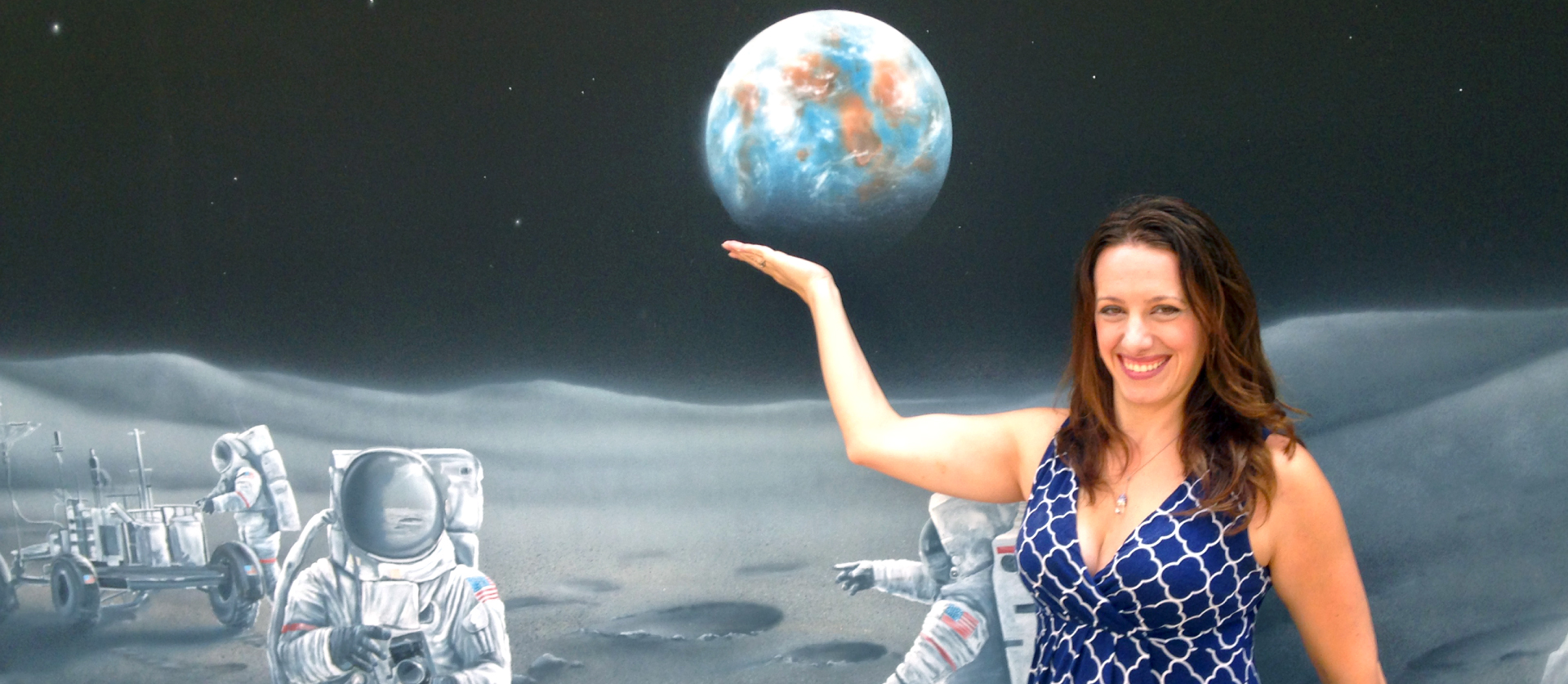 Laura Forczyk poses in front of a space mural.